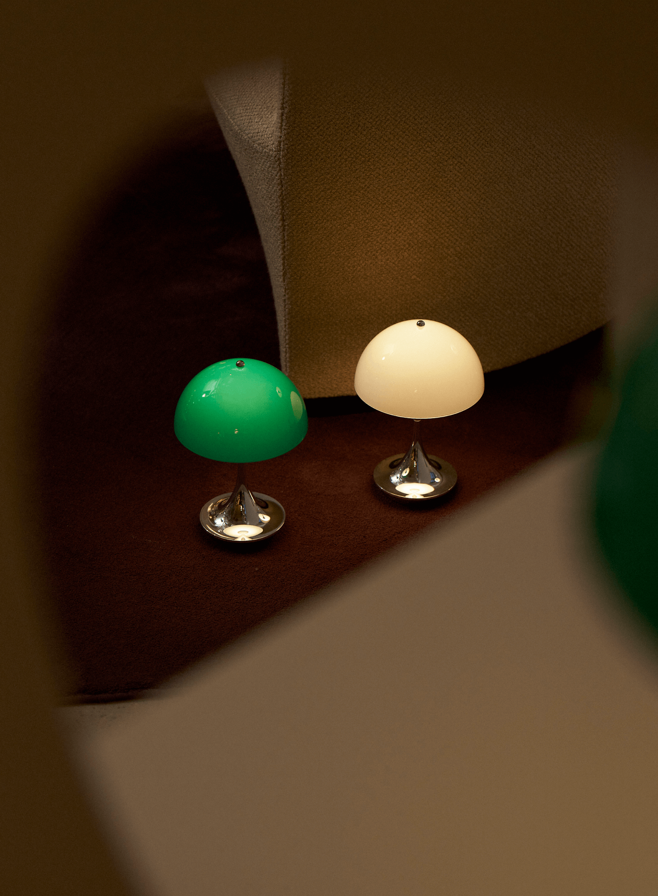 To Panthella bordlamper i Original colours ved loungestol, © 2025 Louis Poulsen.
