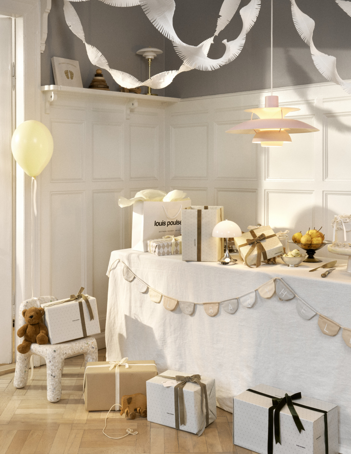 Panthella Portable and PH lamps on a party table with gifts and decorations, © 2025 Louis Poulsen.