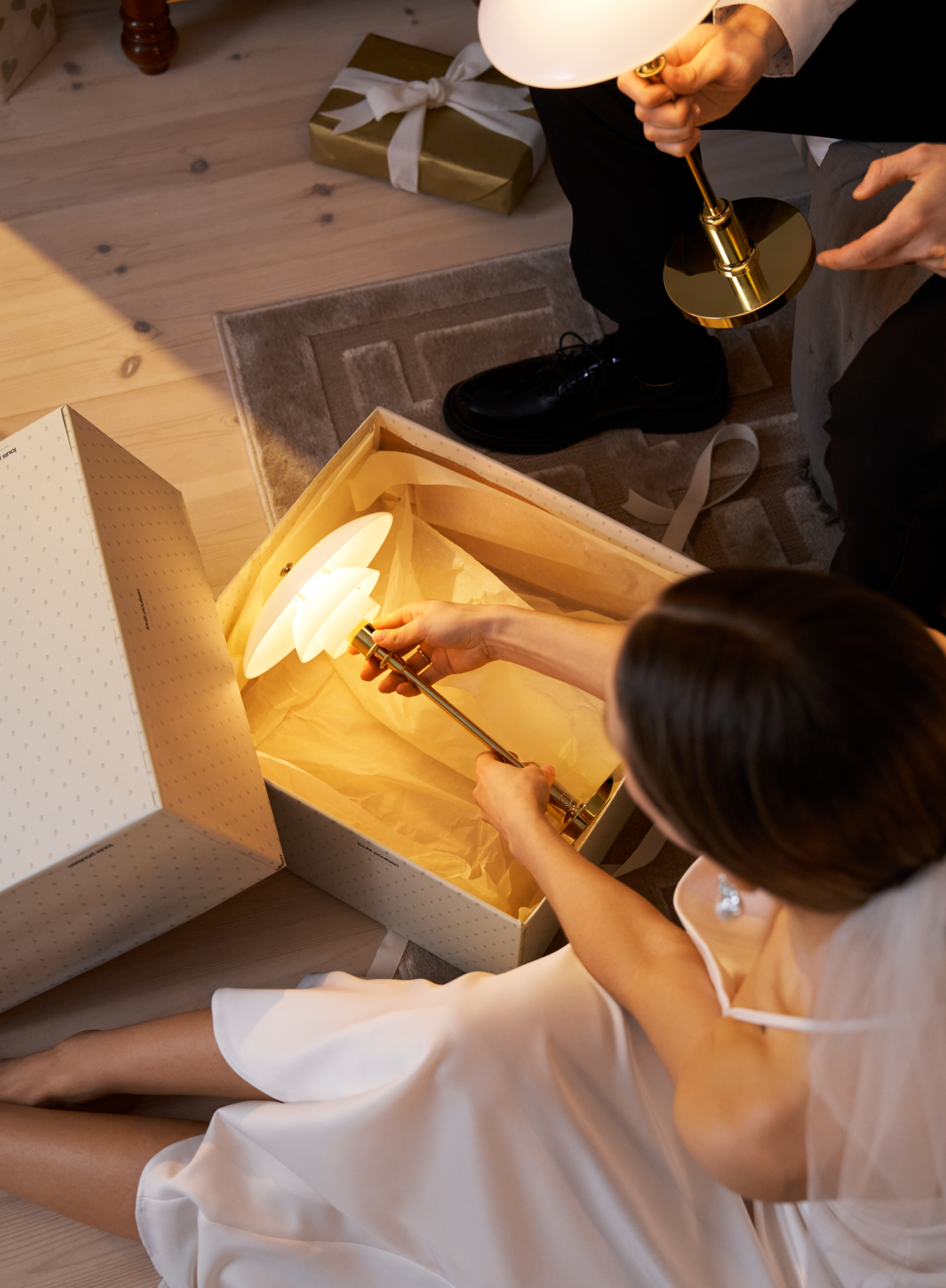 Bride opens gift box revealing PH 2/1 portable lamp, © 2025 Louis Poulsen.