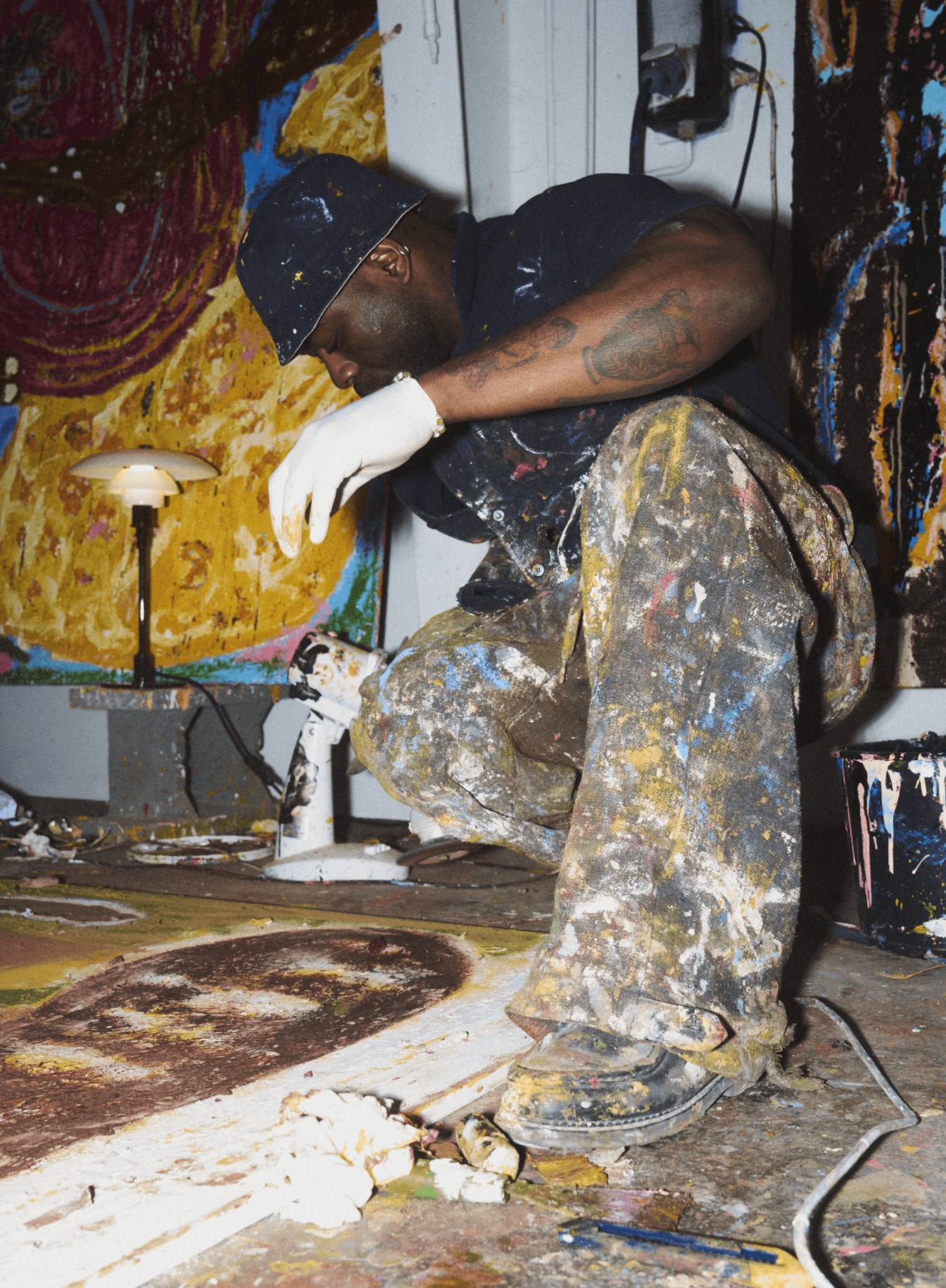 Jack Kabangu in his studio beside a lit PH 2/1 Glossy Burgundy, © 2025 Louis Poulsen.