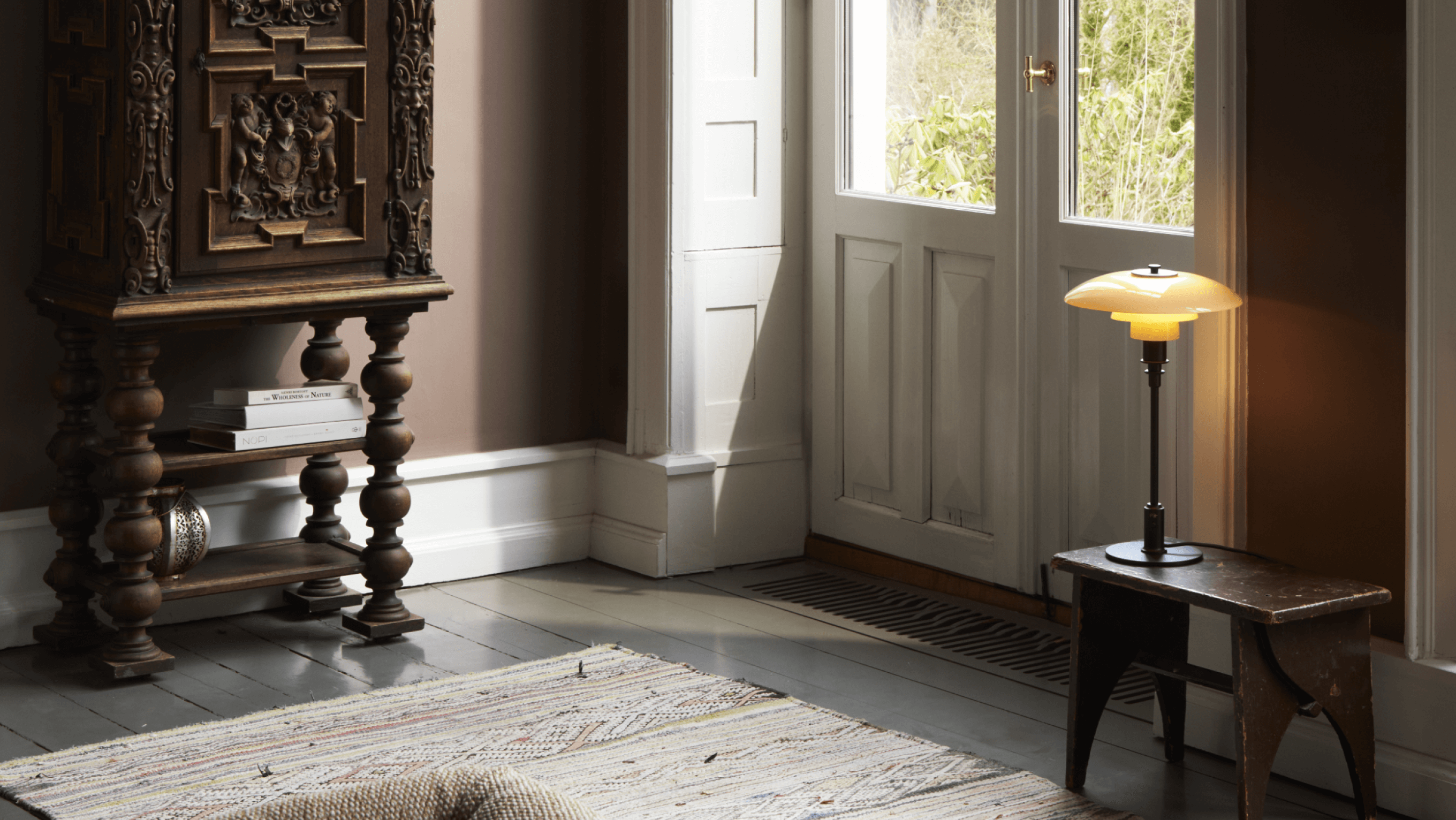 PH 3/2 Limited Edition Table Lamp on wooden stool in sunlit interior, © 2025 Louis Poulsen.