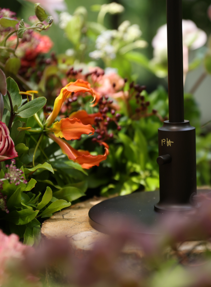 Base of PH 3/2 Limited Edition Table Lamp with PH signature among flowers, © 2025 Louis Poulsen.