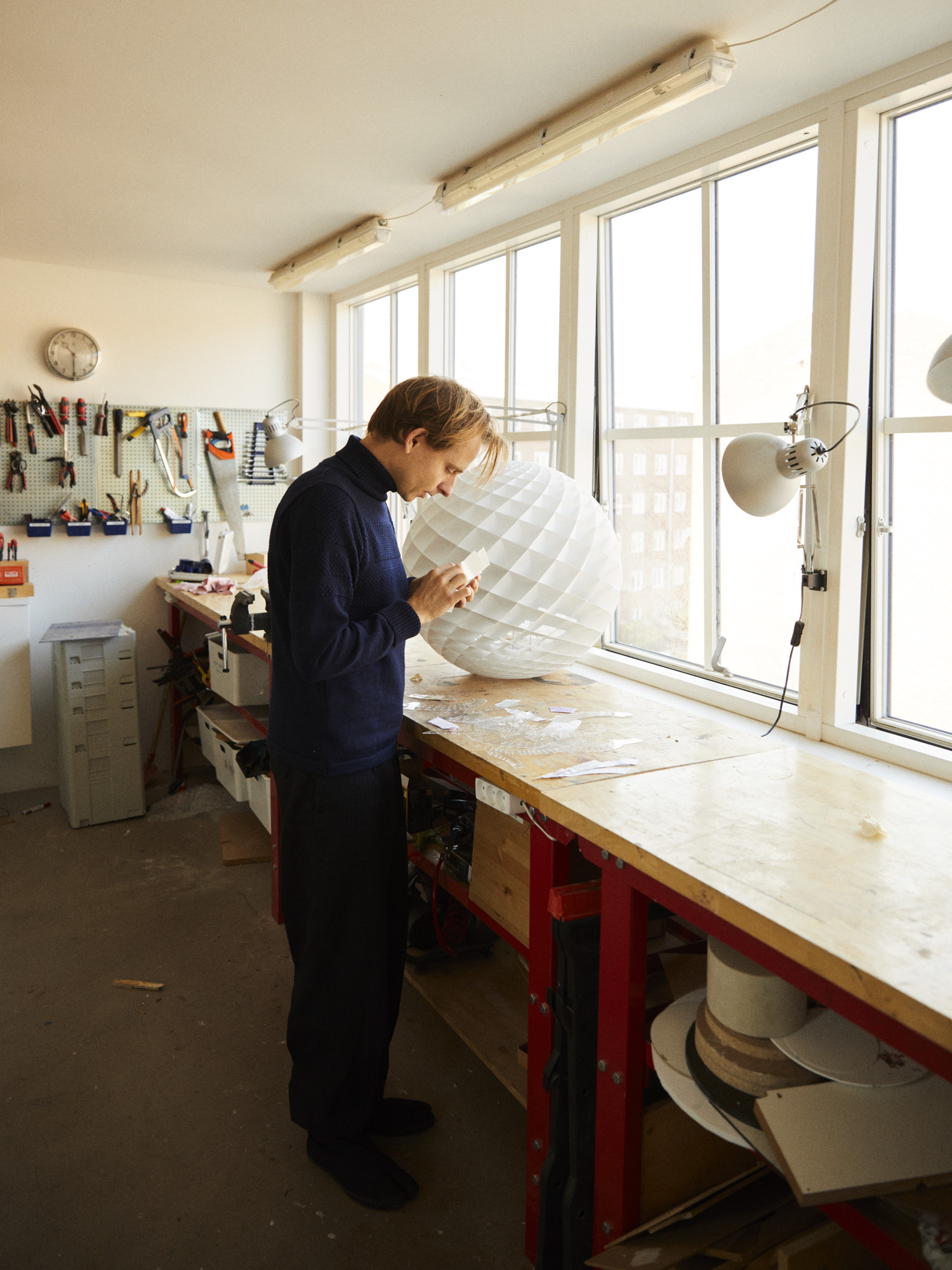 Øivind Slaatto arbejder med Patera pendel i sit lyse værksted, © 2025 Louis Poulsen.