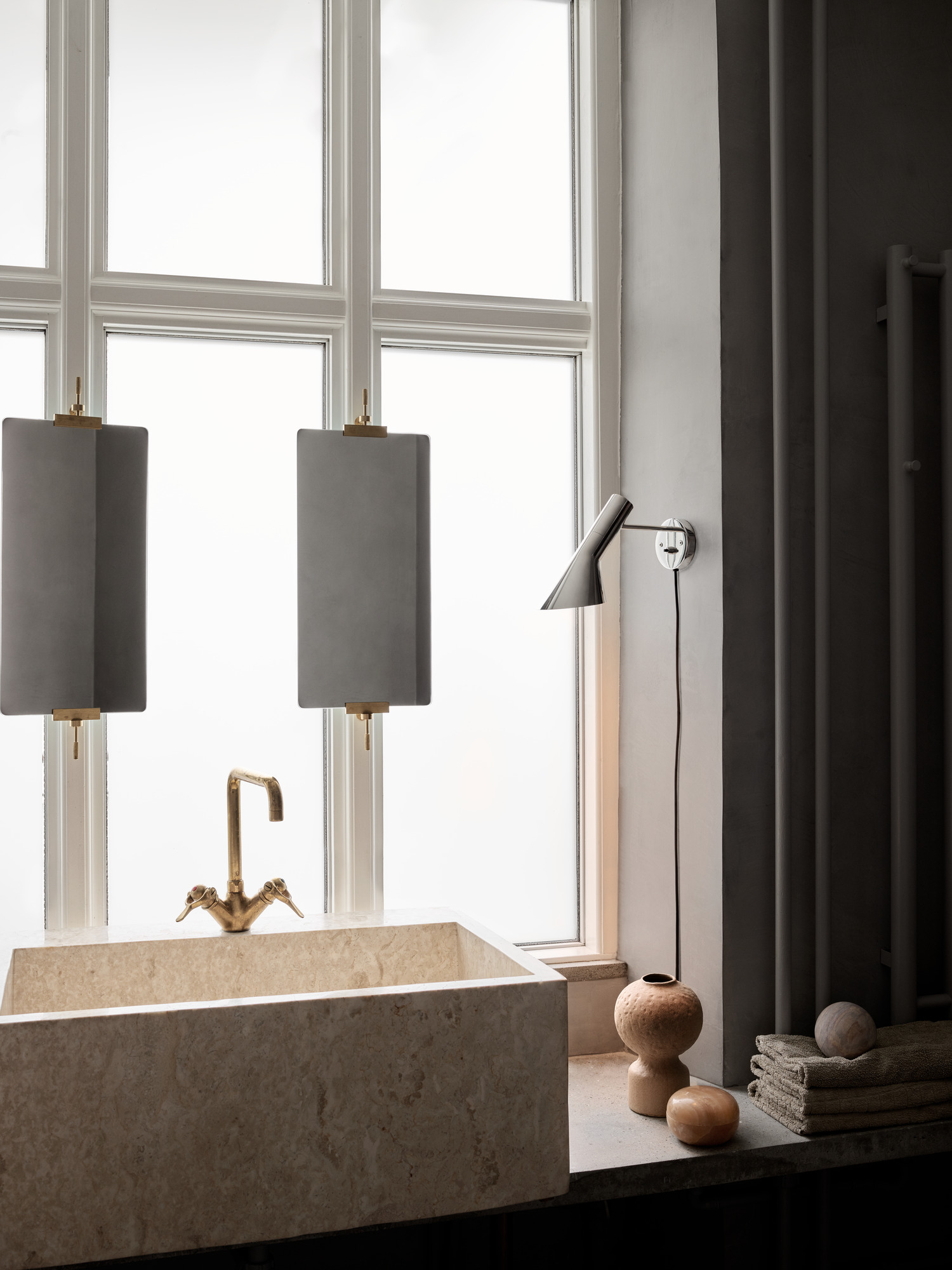 AJ Wall in stainless steel beside bathroom sink and window, © 2025 Louis Poulsen.