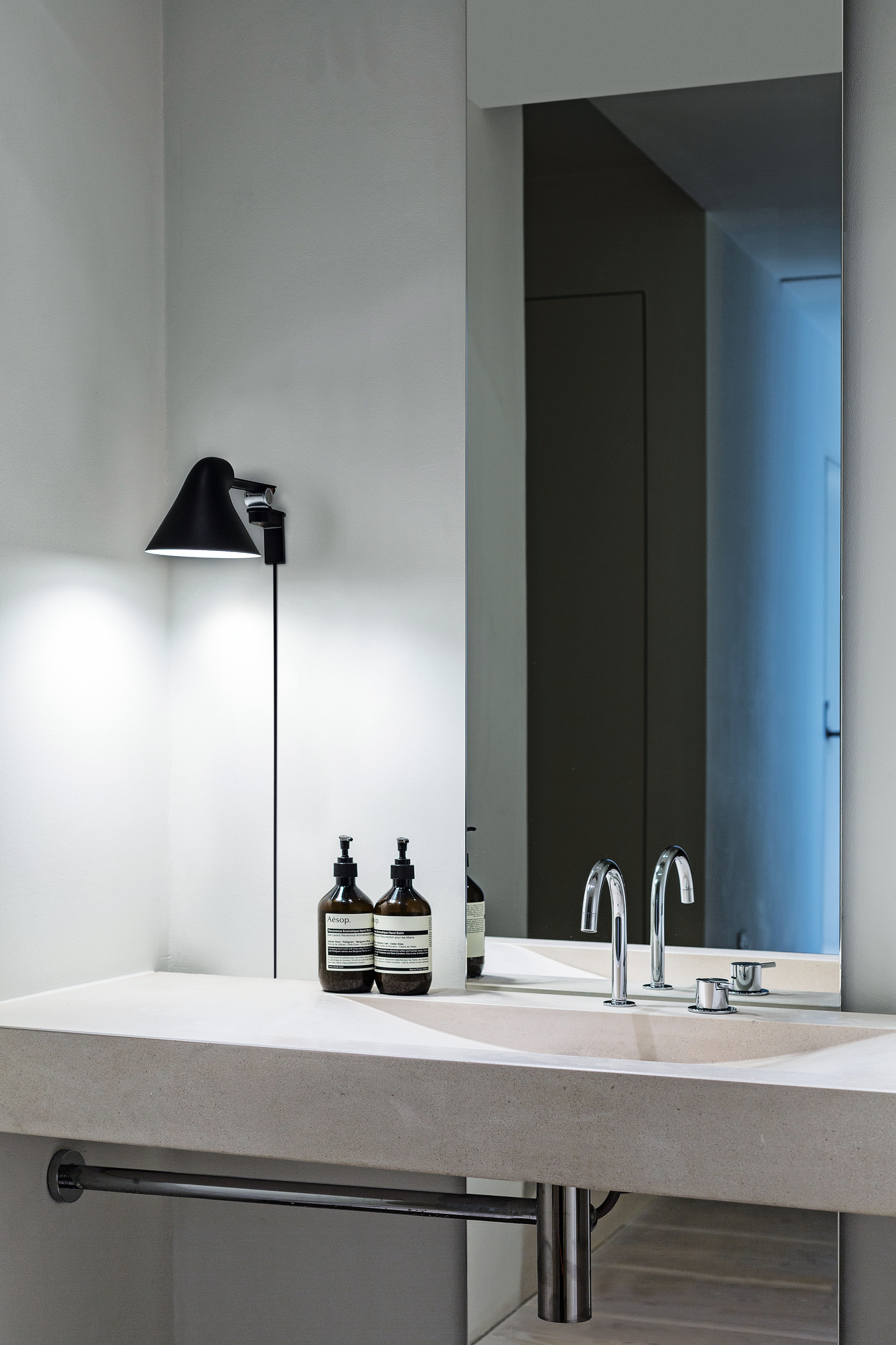NJP Wall in Black lighting bathroom sink area, © 2025 Louis Poulsen.
