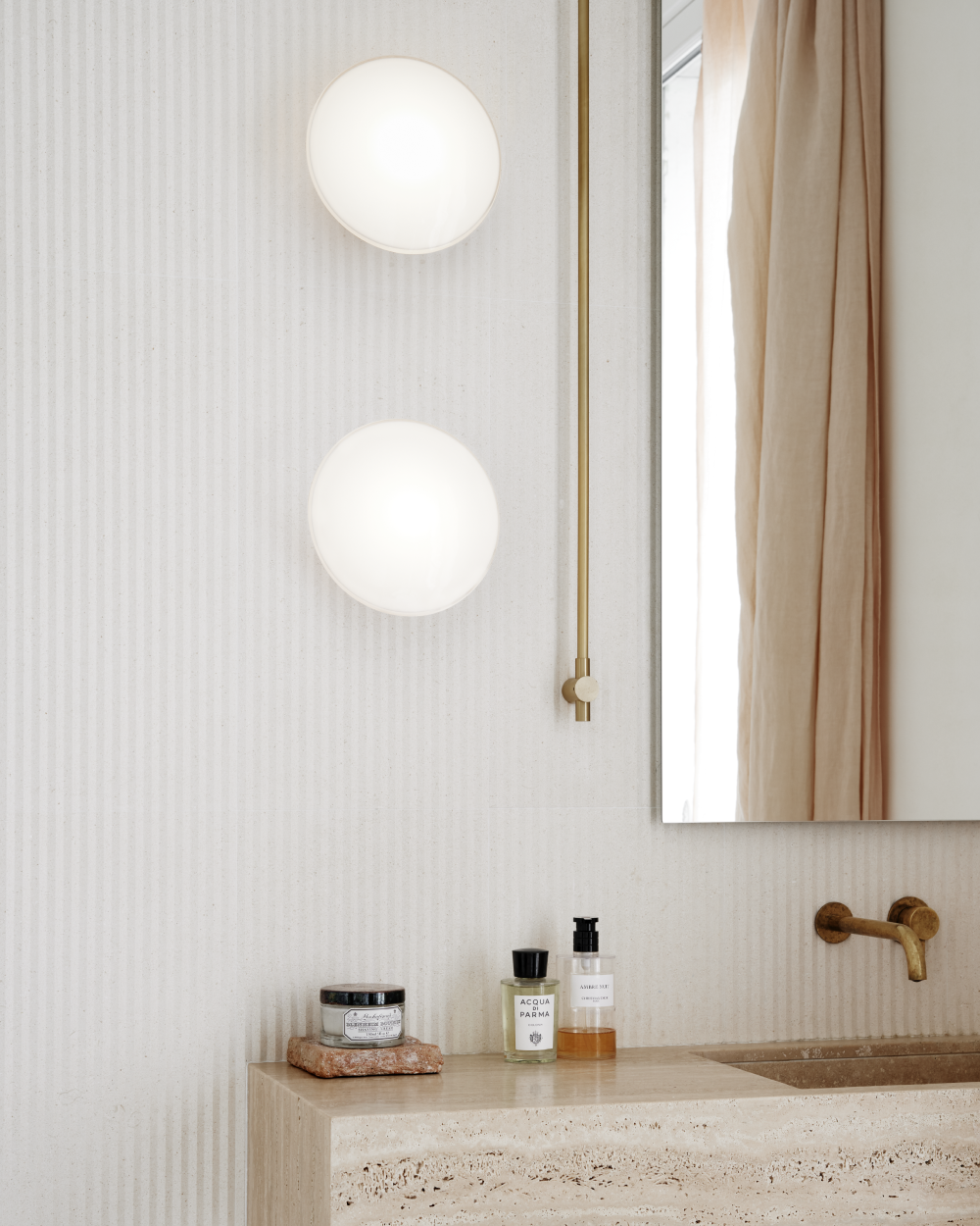 Lampes murales AJ Eklipta au-dessus du lavabo dans une lumière douce, © 2025 Louis Poulsen.