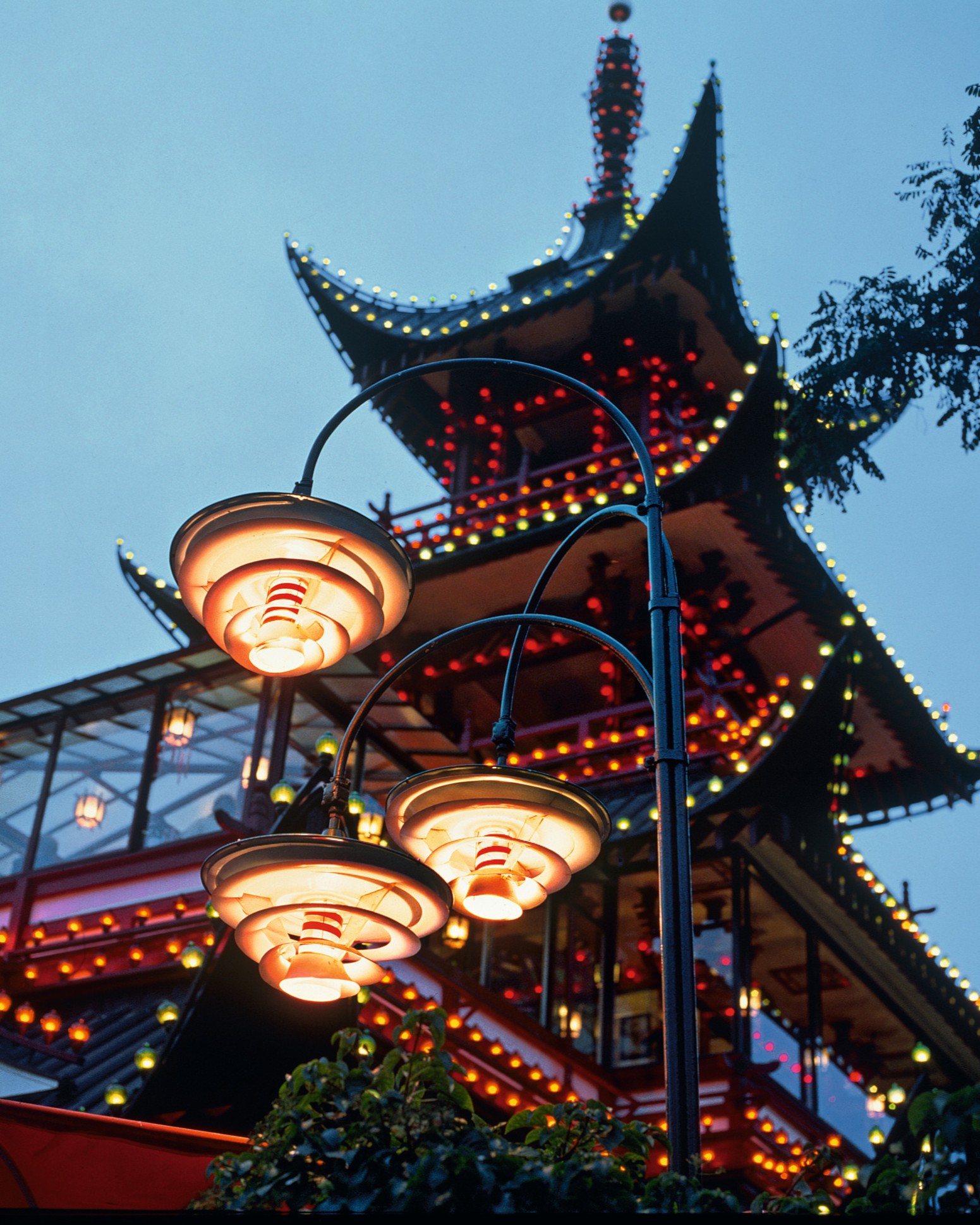 Lámparas PH exteriores iluminan la pagoda de Tivoli al atardecer, © 2025 Louis Poulsen.