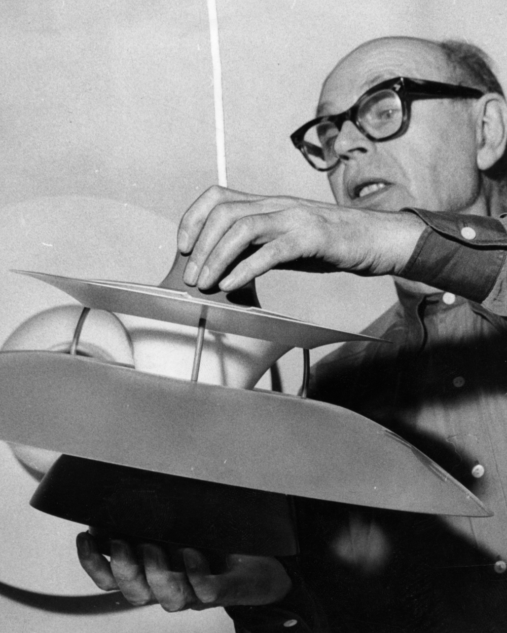 Poul Henningsen ajusta una lámpara PH multicapas durante su trabajo, © 2025 Louis Poulsen.