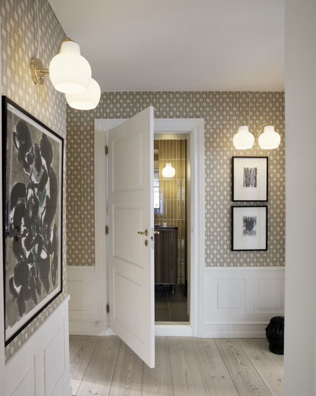 VL Ring Crown 1 and 2 wall lamps illuminating patterned hallway, © 2025 Louis Poulsen.
