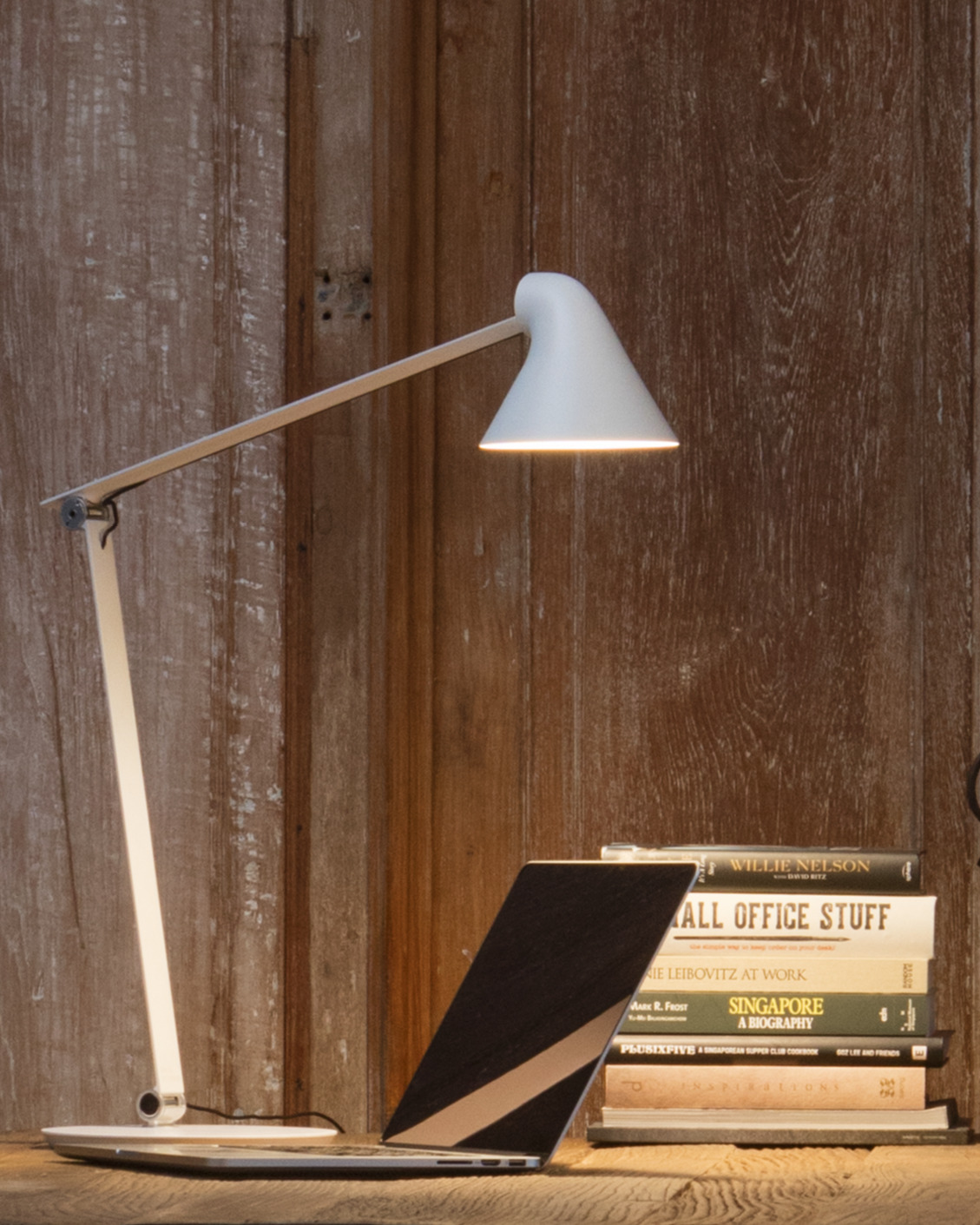 NJP Table in White illuminating desk with laptop and books, © 2025 Louis Poulsen.